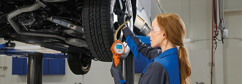 A Subaru technician checking tire pressure. | Flow Subaru Burlington in Burlington NC