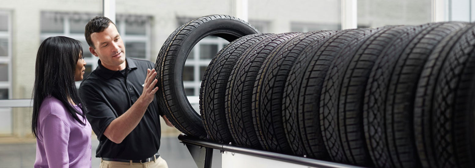 Subaru service representative showing customer a tire. | Flow Subaru Burlington in Burlington NC